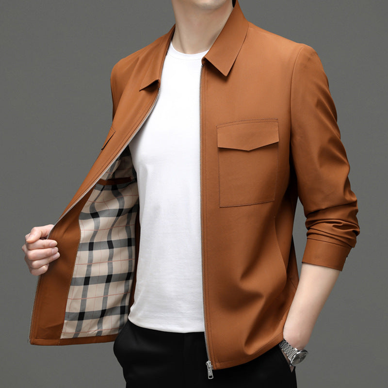Giacca uomo marrone con zip aperta, tasche frontali, interno a quadri, indossata su maglietta bianca. Moda maschile elegante e casual.