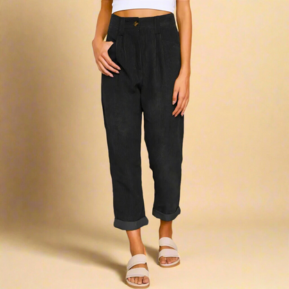 Pantaloni neri a vita alta, stile casual, con risvolto, indossati da una donna in top bianco. Moda femminile, abbigliamento trendy, look estivo.