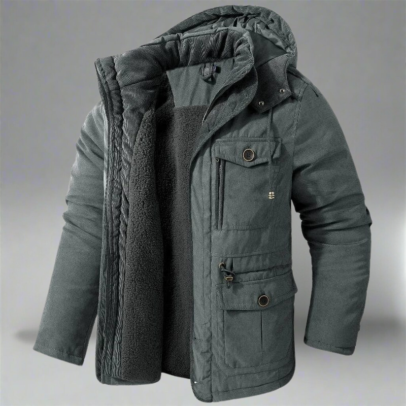 Giacca invernale grigia da uomo con cappuccio, imbottitura in pile, tasche multiple e chiusura a zip. Ideale per climi freddi e look casual.