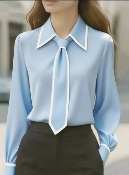 Damebluse med knaplukning foran, bred krave og kontrastkanter – elegant stil