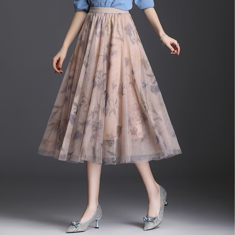 Gonna lunga in tulle floreale, elegante e vaporosa, indossata con camicetta azzurra e scarpe col tacco. Moda femminile, abbigliamento chic.