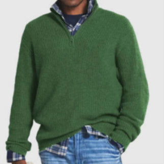 Maglione verde uomo, collo alto, indossato sopra camicia a quadri blu, abbinato a jeans. Moda casual autunnale, abbigliamento maschile elegante.