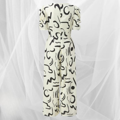 Tuta elegante bianca con motivi astratti neri, maniche corte e taglio lungo. Moda femminile, abbigliamento estivo, stile moderno.