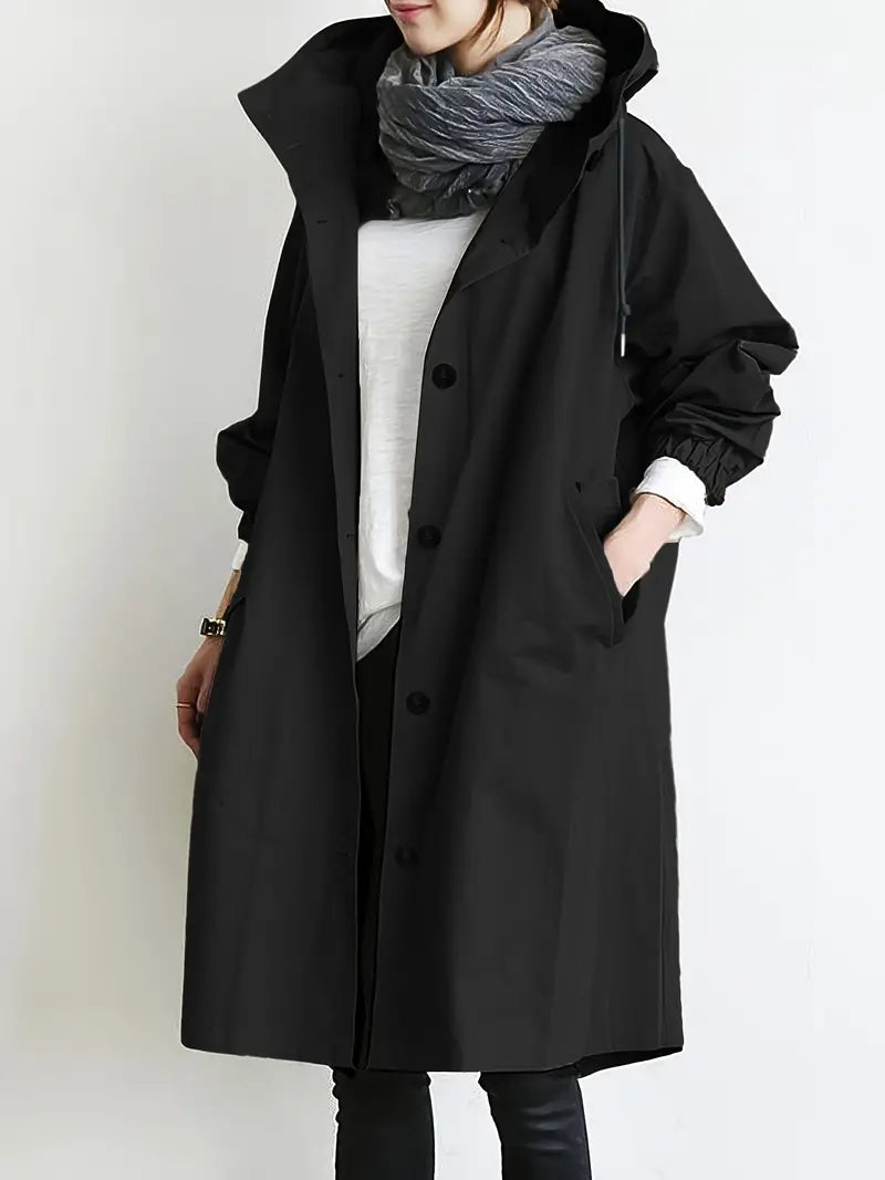 Donna con cappotto nero lungo, sciarpa grigia e camicia bianca. Moda autunnale, abbigliamento casual elegante. Stile minimalista.