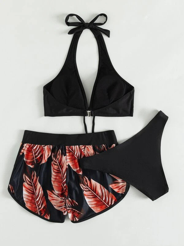 Bikini nero con top a triangolo e pantaloncini a foglie rosse, moda mare donna, abbigliamento estivo elegante e trendy.