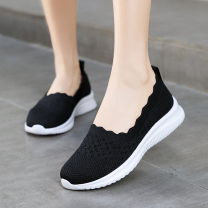 Scarpe da ginnastica nere da donna con suola bianca, design traforato, comode e leggere, ideali per camminata e sport casual.