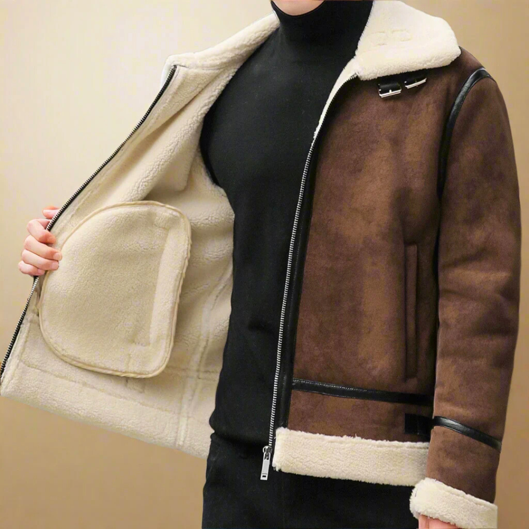 Giacca invernale uomo in pelle scamosciata marrone con fodera in pelliccia sintetica bianca, chiusura zip, dettagli neri, stile casual elegante.