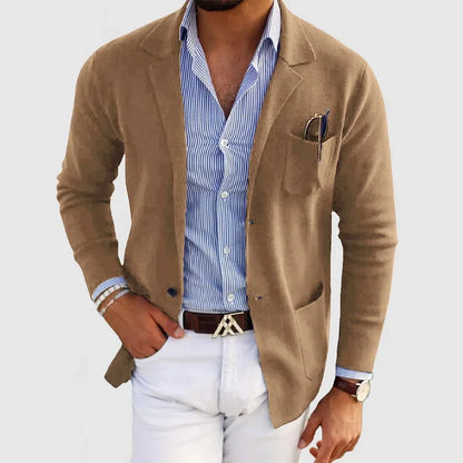 Uomo in giacca beige su camicia a righe blu, pantaloni bianchi. Look elegante e casual, moda maschile, stile moderno, accessori raffinati.