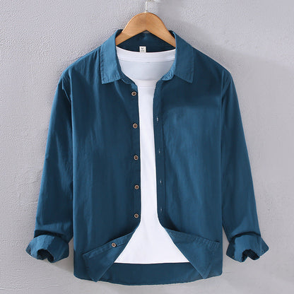 Camicia casual blu da uomo su gruccia, con colletto classico e maniche lunghe, abbinata a t-shirt bianca. Moda maschile, abbigliamento elegante.