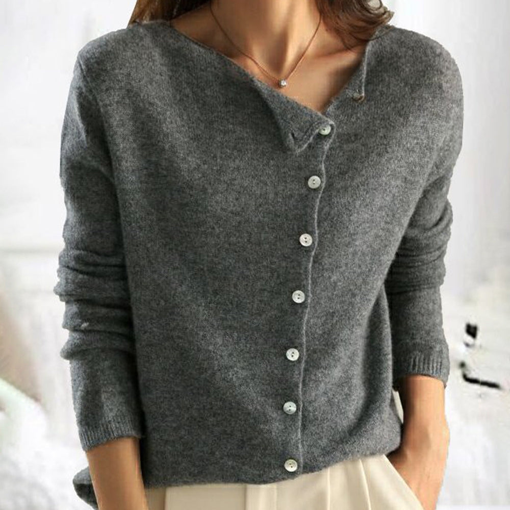 Maglione grigio donna in cashmere con bottoni bianchi, design asimmetrico, maniche lunghe. Elegante e caldo, ideale per moda autunnale.