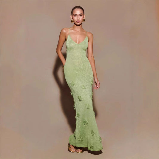 Modella in abito lungo verde con dettagli floreali, posa elegante su sfondo neutro. Moda femminile, abbigliamento da sera, tendenze 2023.