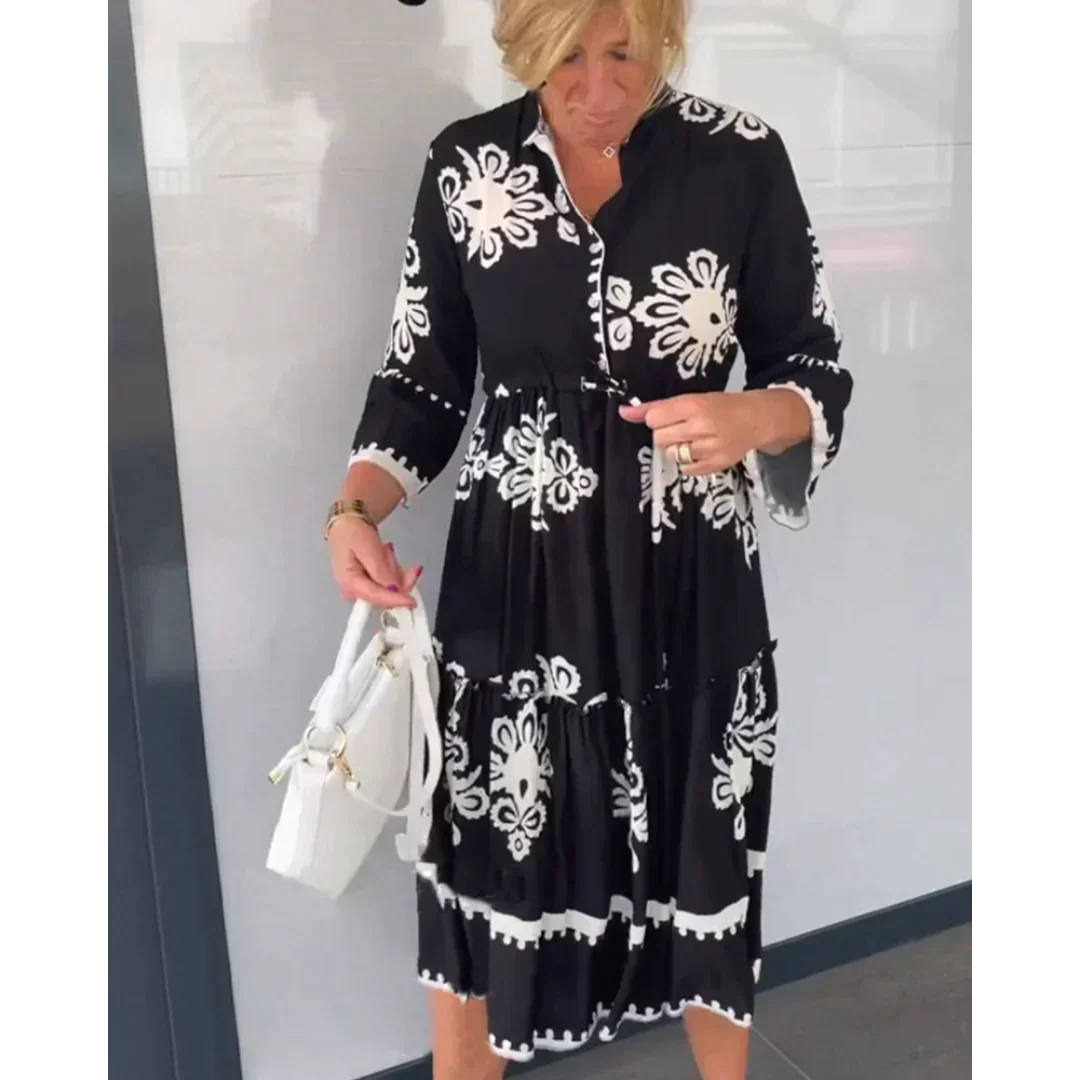 Abito nero con motivi floreali bianchi indossato da una donna, borsa bianca a mano. Moda femminile elegante, abbigliamento estivo casual.