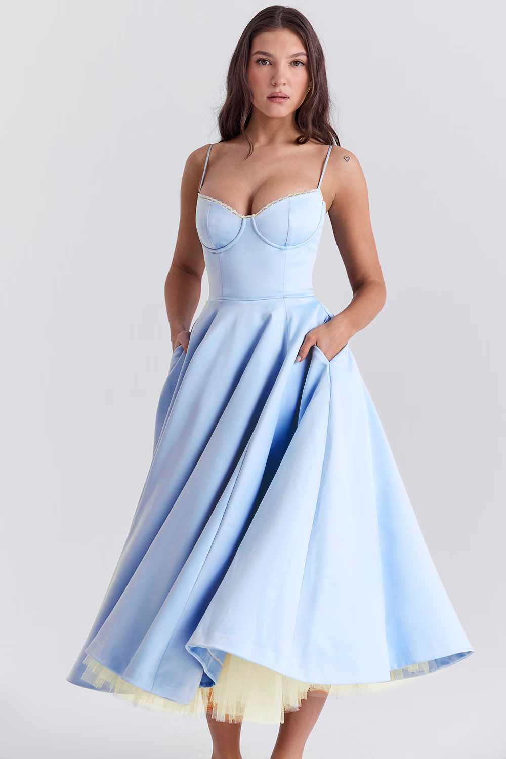 Donna in abito da sera azzurro con spalline sottili e gonna ampia, stile elegante. Vestito da cerimonia, moda femminile, abbigliamento elegante.