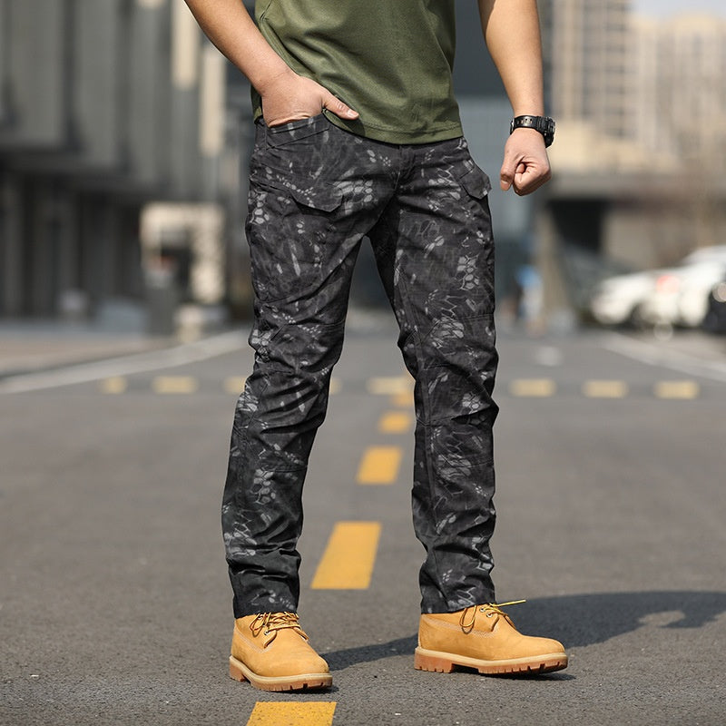 Uomo in strada indossa pantaloni mimetici neri e scarponcini gialli, moda urbana, abbigliamento casual maschile, tendenza streetwear.