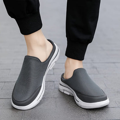 Scarpe slip-on grigie da uomo su pavimento in pietra, design casual e traspirante, perfette per passeggiate e tempo libero.