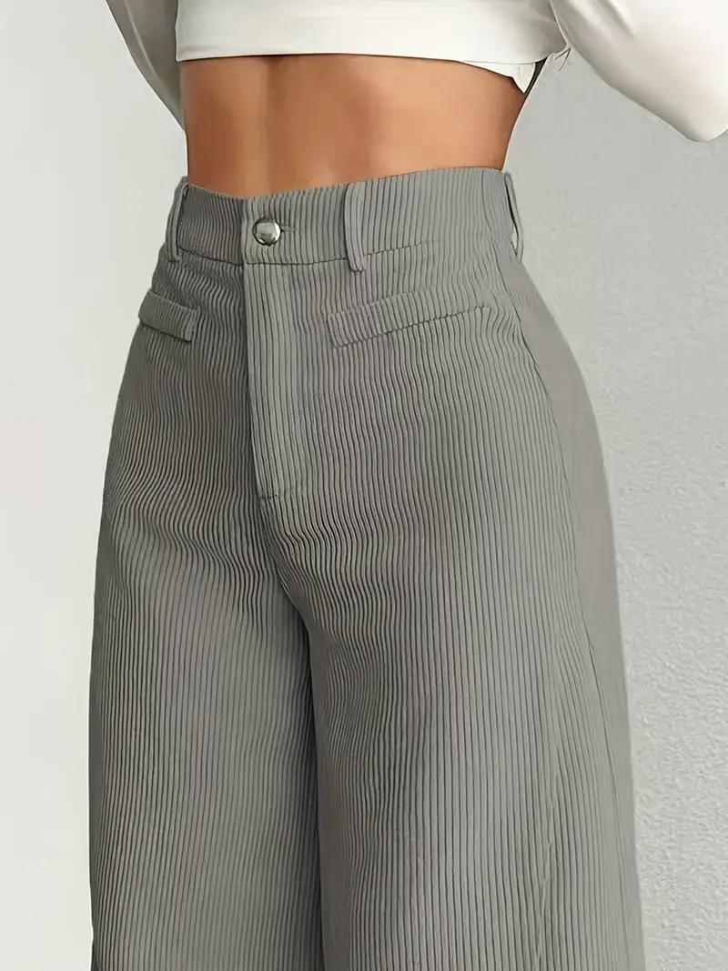 Pantaloni a vita alta grigi a righe verticali, indossati con top bianco corto. Stile elegante e moderno, perfetto per moda femminile autunnale.
