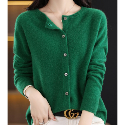 Maglione verde in cashmere con bottoni, indossato da una donna. Moda autunnale elegante, abbinato a cintura di lusso. Stile casual chic.