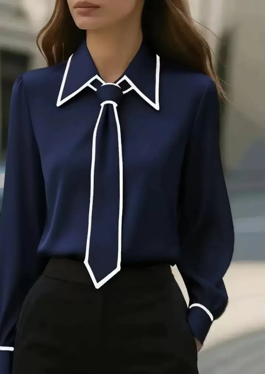 Damebluse med knaplukning foran, bred krave og kontrastkanter – elegant stil