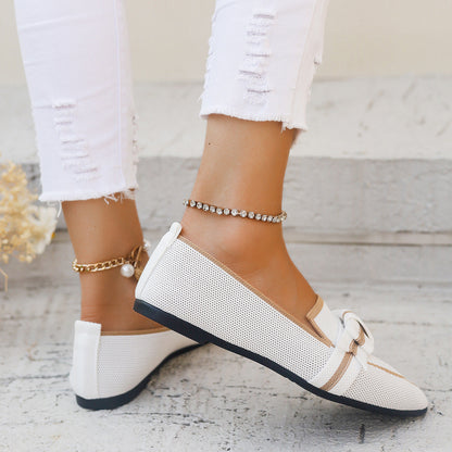 Scarpe da donna bianche eleganti con fiocco, indossate con jeans strappati bianchi. Accessori: cavigliere dorate e argentate. Moda estiva casual.