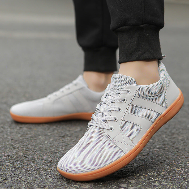 Sneakers til mænd med flyknit, bred pasform, flad sål og åndbart meshdesign.