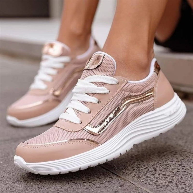 Scarpe da ginnastica rosa con dettagli dorati, suola bianca spessa, design moderno e sportivo, perfette per moda casual e attività all'aperto.