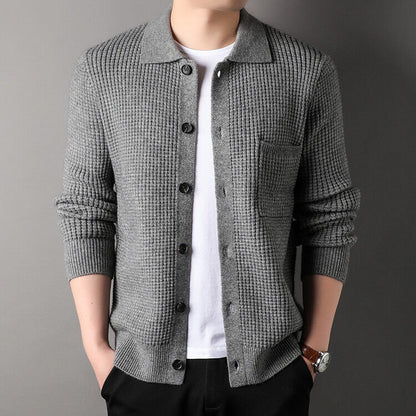 Cardigan grigio a maglia grossa con bottoni, indossato su maglietta bianca. Moda uomo, abbigliamento casual elegante, stile autunnale.