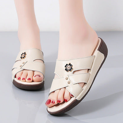 Sandali donna beige con decorazione floreale, suola marrone, design incrociato. Scarpe estive eleganti, comode, ideali per look casual.