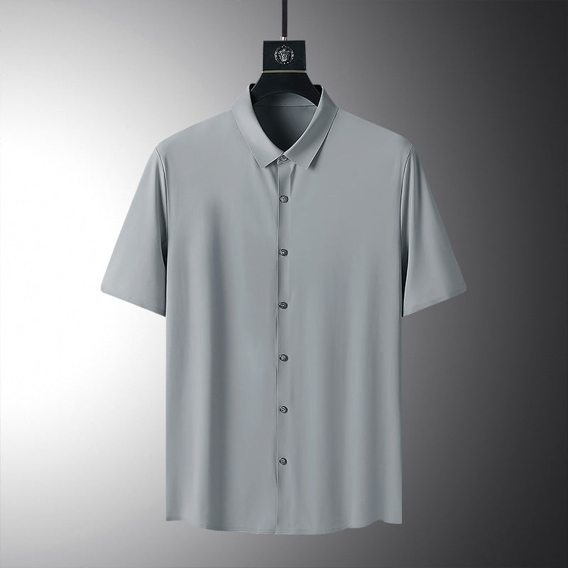 Camicia grigia a maniche corte su sfondo neutro, design minimalista, tessuto leggero, ideale per moda estiva uomo, abbigliamento casual elegante.