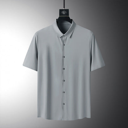 Camicia grigia a maniche corte su sfondo neutro, design minimalista, tessuto leggero, ideale per moda estiva uomo, abbigliamento casual elegante.
