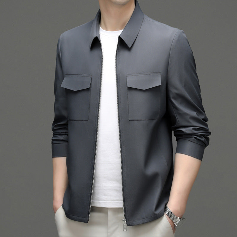 Giacca uomo grigia elegante, stile casual, con zip frontale e tasche, indossata su maglietta bianca. Moda maschile contemporanea.