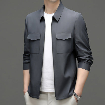 Giacca uomo grigia elegante, stile casual, con zip frontale e tasche, indossata su maglietta bianca. Moda maschile contemporanea.