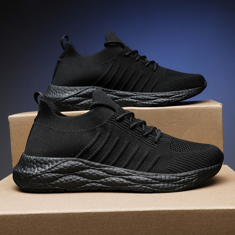 Scarpe da ginnastica nere su scatole di cartone, design moderno e suola testurizzata. Scarpe sportive leggere, ideali per corsa e allenamento.