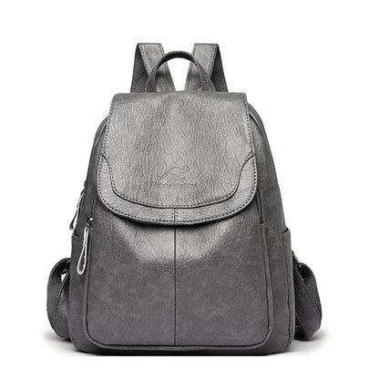 Zaino in pelle grigia elegante con tasche laterali e chiusura a zip, ideale per scuola o lavoro. Design moderno e resistente.