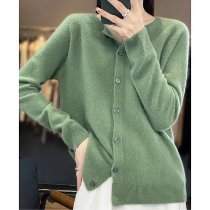 Donna con cardigan verde in cashmere, abbottonato, in un negozio di abbigliamento. Moda autunnale, stile elegante, tessuto morbido e caldo.