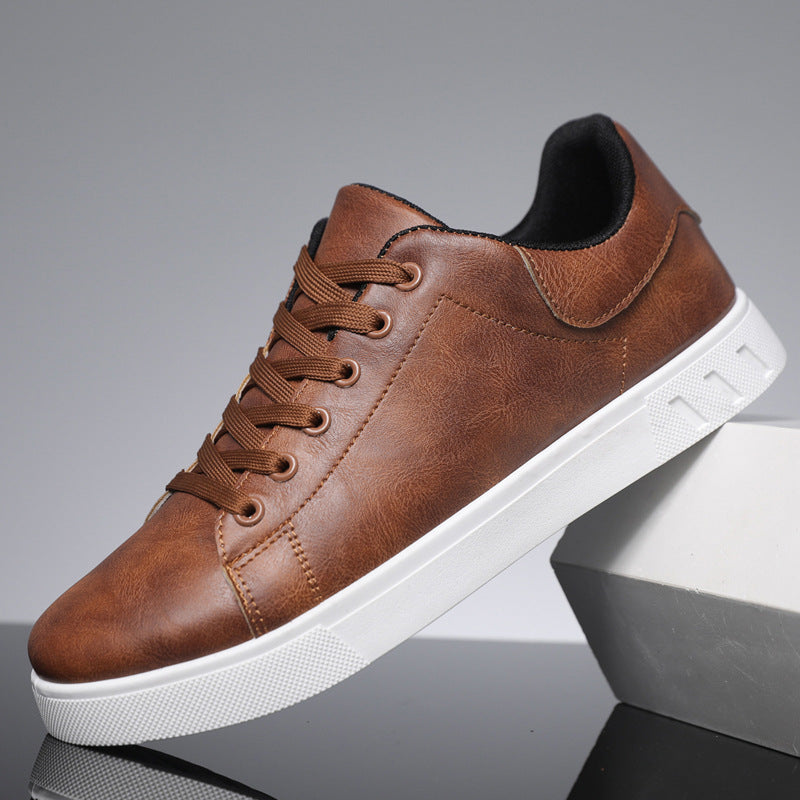 Scarpa da ginnastica marrone in pelle sintetica con suola bianca, design casual, lacci marroni, ideale per moda uomo e comfort quotidiano.