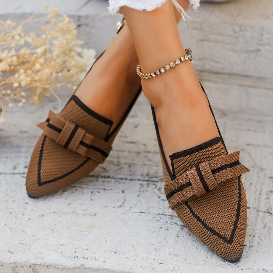 Scarpe eleganti da donna in tessuto marrone con fiocco, su sfondo di pietra chiara. Design moderno, perfette per moda autunnale e look casual chic.
