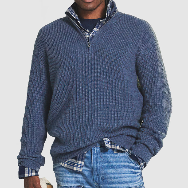Maglione blu a collo alto con zip, indossato sopra camicia a quadri blu e jeans. Moda uomo casual, abbigliamento autunnale elegante.