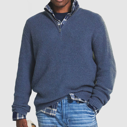 Maglione blu a collo alto con zip, indossato sopra camicia a quadri blu e jeans. Moda uomo casual, abbigliamento autunnale elegante.