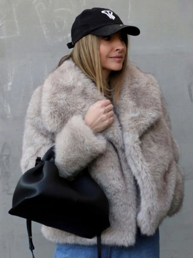 Donna con cappotto di pelliccia beige, cappello nero e borsa nera. Moda invernale, stile casual chic, abbigliamento trendy.