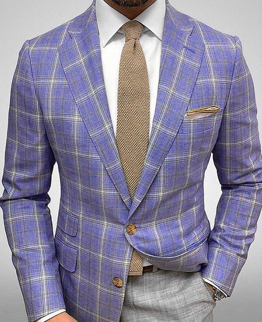 Giacca uomo a quadri blu e grigi, cravatta beige, fazzoletto da taschino coordinato. Elegante abbigliamento formale maschile.