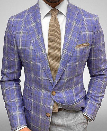 Giacca uomo a quadri blu e grigi, cravatta beige, fazzoletto da taschino coordinato. Elegante abbigliamento formale maschile.