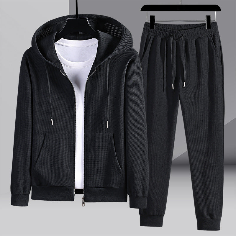 Tuta sportiva nera da uomo con felpa con cappuccio e pantaloni, tessuto a coste, ideale per abbigliamento casual e attività sportive.