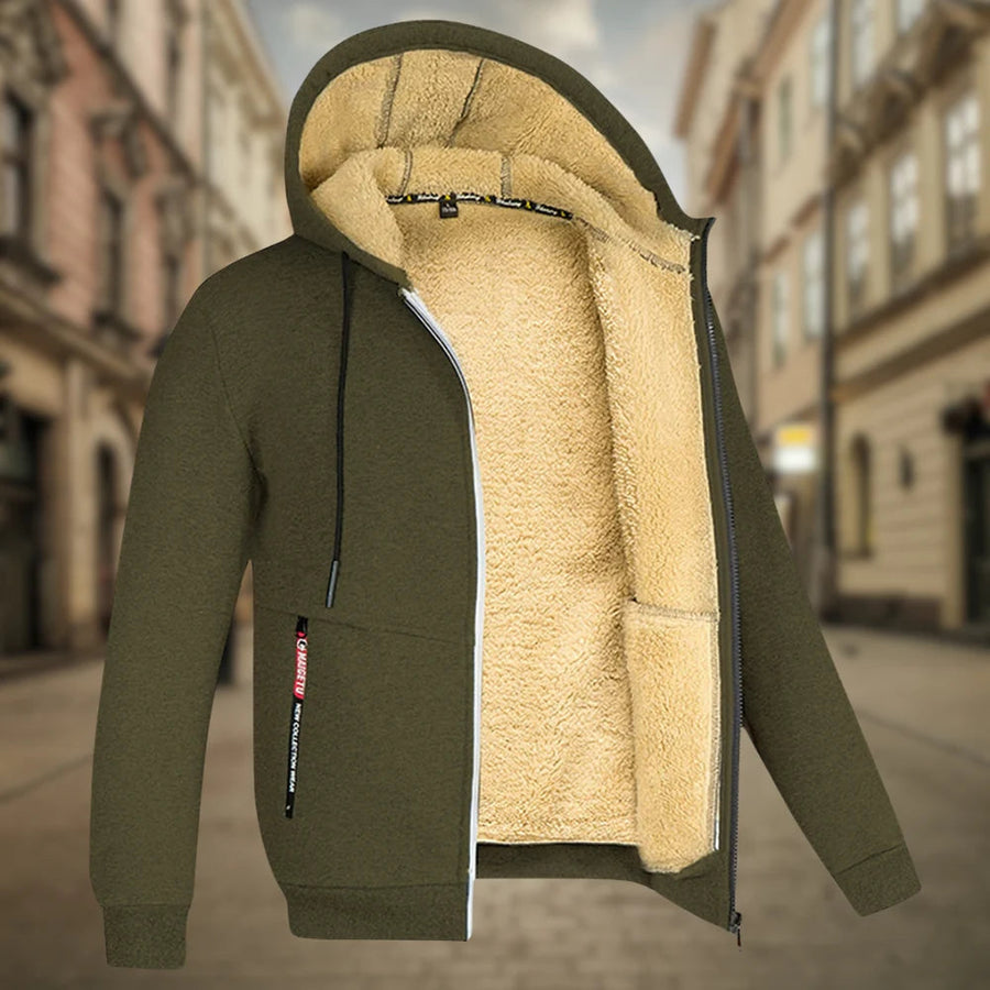 Giacca invernale con cappuccio, foderata in pelliccia sintetica beige, colore verde oliva, zip frontale, sfondo urbano sfocato.