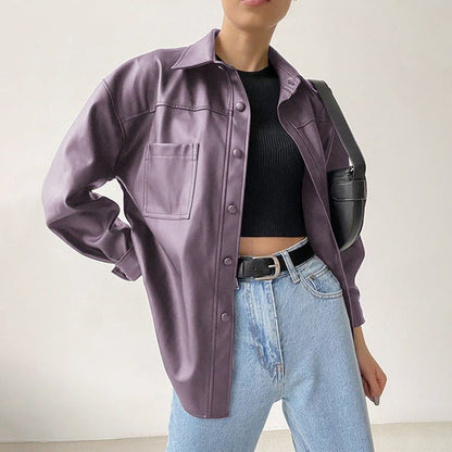 Donna con camicia oversize viola, top nero e jeans chiari, borsa a tracolla nera. Moda casual femminile, stile urbano, tendenze abbigliamento 2023.
