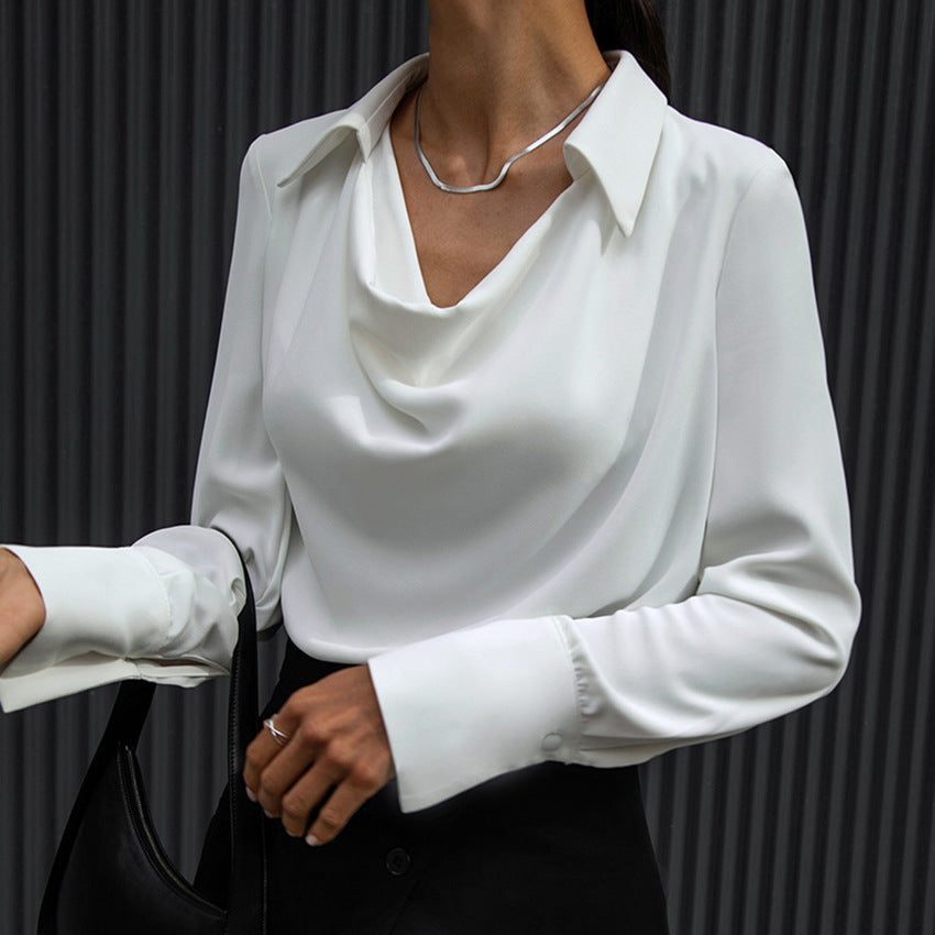 Camicia bianca elegante da donna con scollo a cascata, abbinata a collana minimalista e borsa nera. Moda femminile sofisticata e moderna.