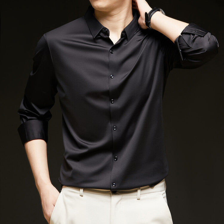 Camicia nera elegante da uomo con maniche lunghe arrotolate, indossata con pantaloni chiari. Moda maschile, abbigliamento formale, stile moderno.