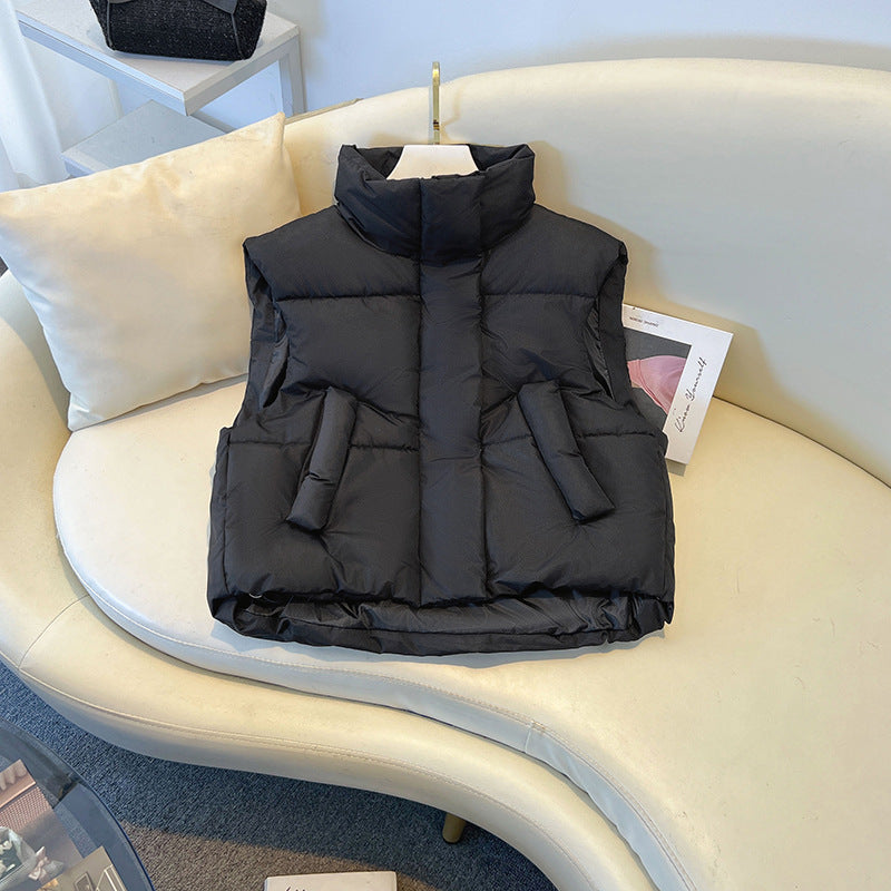 Gilet imbottito nero su divano bianco, moda invernale, abbigliamento casual, senza maniche, caldo, stile moderno, arredo elegante.