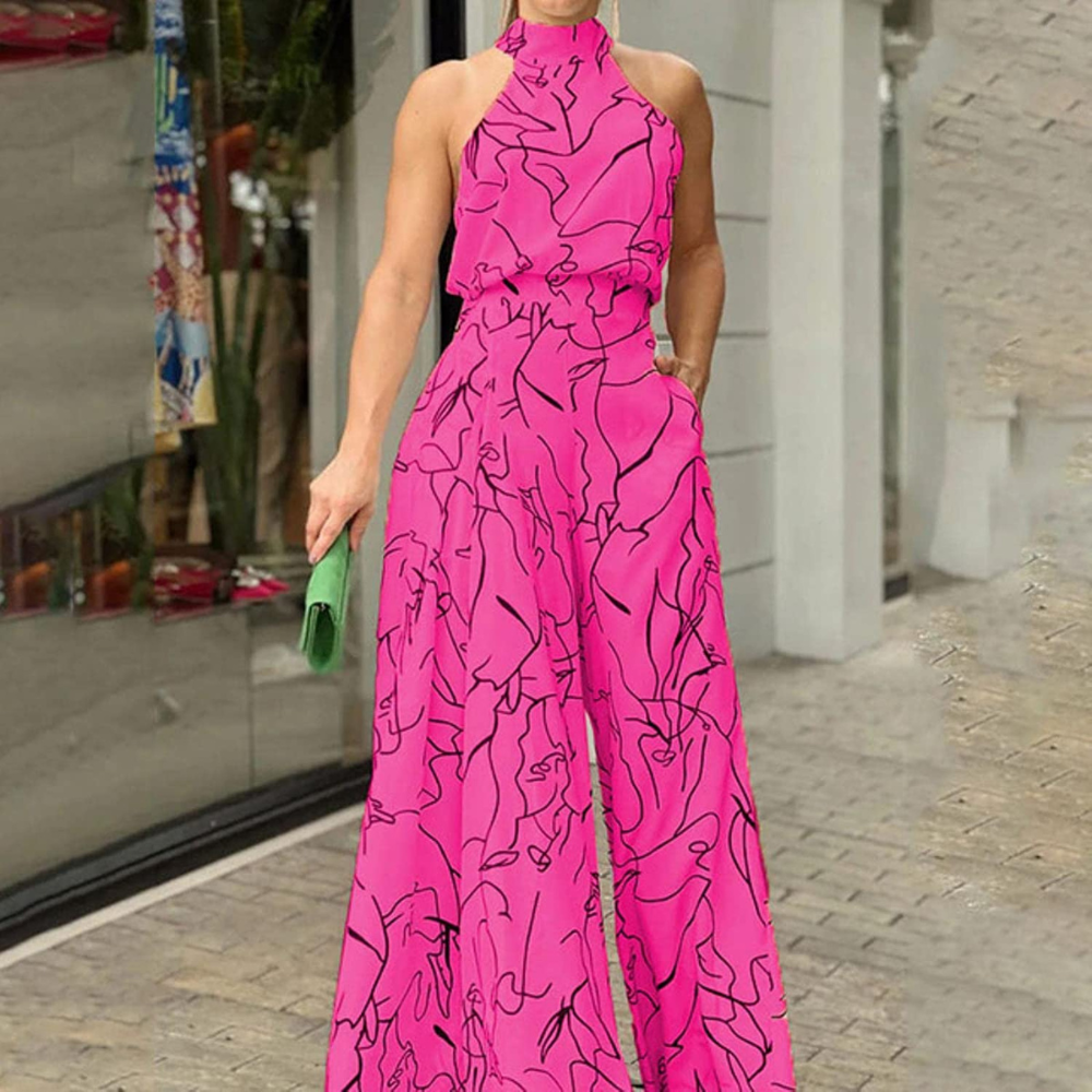 Donna in tuta rosa con motivo astratto nero, borsa verde, davanti a una vetrina. Moda estiva elegante, abbigliamento femminile trendy.