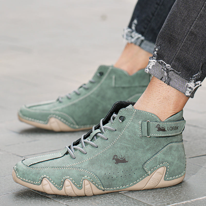 Scarpe da ginnastica alte verdi su pavimento grigio, con dettagli beige e logo. Moda casual, jeans strappati. Scarpe uomo trendy e comode.