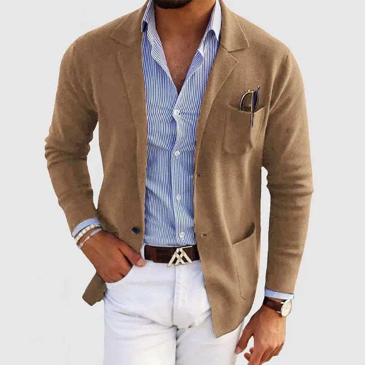 Uomo in giacca beige su camicia a righe blu, pantaloni bianchi. Look elegante e casual, moda maschile, stile moderno.